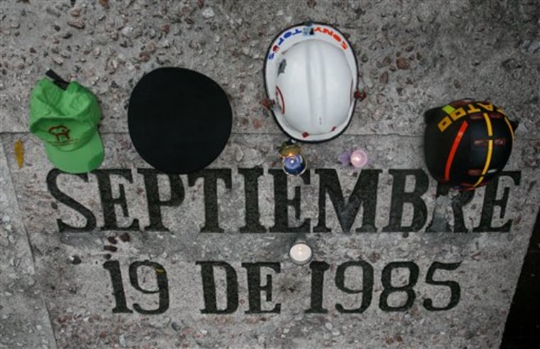 Helmets and caps of "Topos" are seen atop the 1985 earthquake's memorial, during a ceremony to commemorate its 25th anniversary in Mexico City, Sunday, on Sept. 19. 